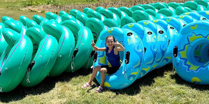 Child Sitting On Row Of Tubes